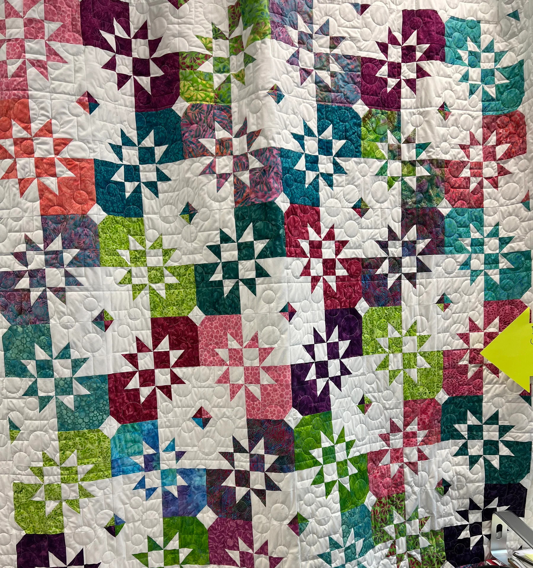 Colorful finished quilt showing detailed circular quilting stitches